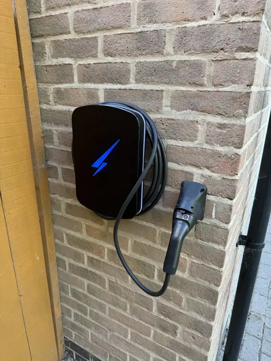 Black wall-mounted EV charger with tethered cable installed on a York home