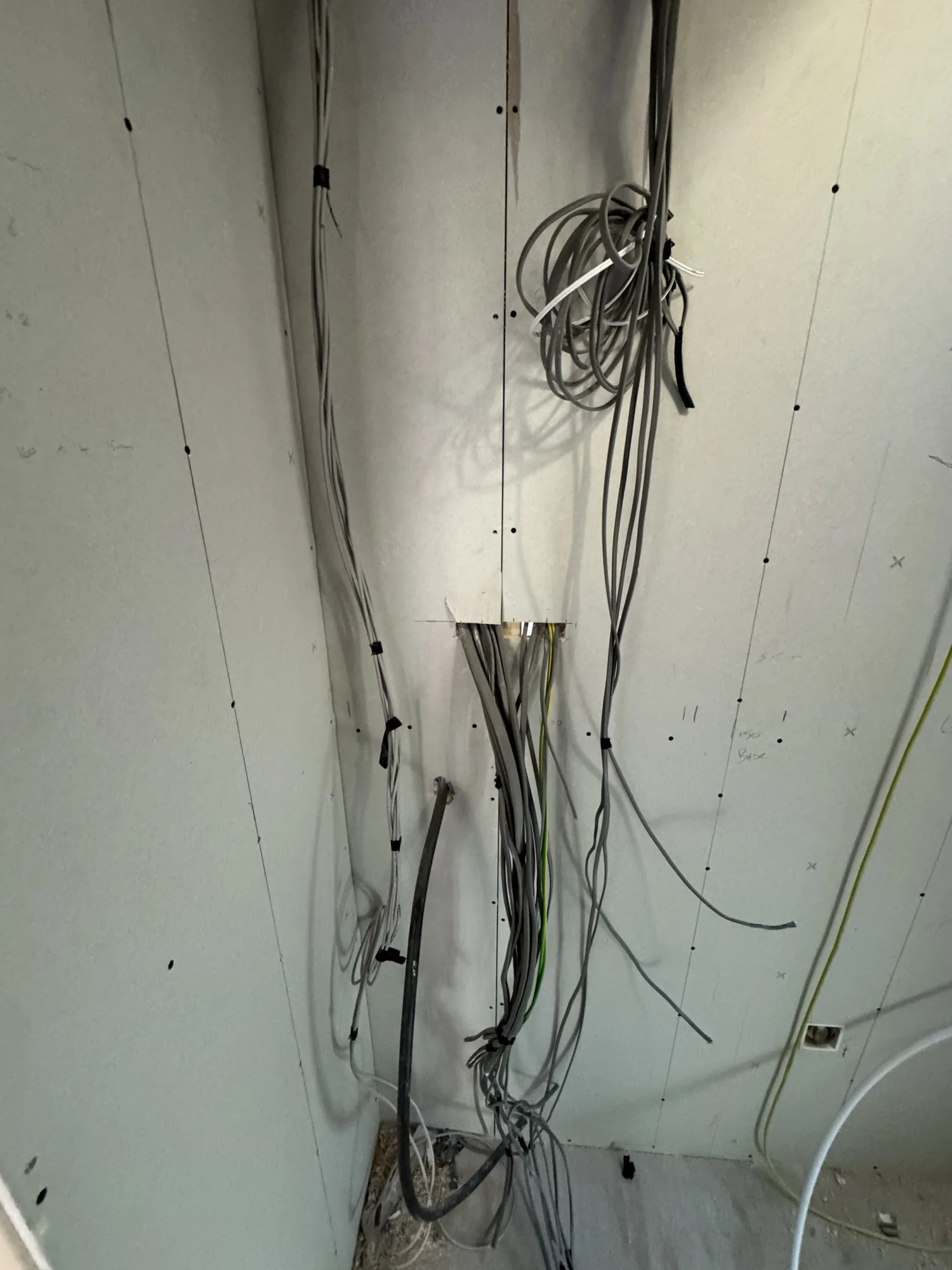 First-fix cables run down a stripped wall during a house rewire